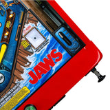 Fliper Stern JAWS 50th Anniversary pinball machine close-up with vibrant design and red cabinet.
