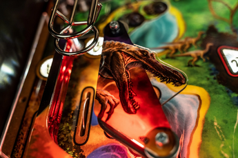 Detail of Fliper Stern Jurassic Park Home Edition Plus with dinosaur graphics and illuminated playfield.